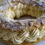 Großzügige und Einfache Strecke: Paris-Brest Ich habe eine fantastische Dessertidee für dich – das Originalrezept von PARIS-BREST, einem Gourmet-Gebäck und einem köstlichen Snack für Pralinenliebhaber. Dieses delikate Dessert ist nicht nur lecker, sondern auch überraschend einfach zuzubereiten. Das Paris-Brest-Rezept ist eines der Desserts, dem ich einfach nicht widerstehen kann. Wenn ich noch etwas Buttercreme übrig habe, füge ich hausgemachte Praliné hinzu, die ich immer aufbewahre, und dann bereite ich den Brandteig für den Köhlerteig vor. Paris-Brest, Brandteig, Konditorcreme und Paris-Brest-Creme – du erhältst alle Tipps, damit dein hausgemachtes Paris-Brest ein voller Erfolg wird! Es ist so verlockend und schnell zubereitet. An einem regnerischen Tag ist dieses Rezept für Paris-Brest eine willkommene Leckerei, besonders in Begleitung einer guten Milchschokolade. ## **Für das Rezept benötigen Sie:** - **Schwierigkeitsgrad:** Einfach - **Anzahl der Personen:** 4 Personen - **Dauer:** 45 Minuten ## Zutaten: ### Für den Brandteig: - 25 cl Wasser - Salz - 70 g Butter - 100 g Mehl - 3 Eier - 70 g Mandelblättchen ### Für die Sahne: - 2 Eiweiß - 125 g Zucker - 80 g Praliné - 155 g Butter ## **Vorbereitung:** 1. Das Wasser erhitzen und die Butter darin schmelzen. Das Mehl hinzufügen und vermengen, bis eine dicke Paste entsteht. 2. Zwei Eier hinzufügen und den Teig eine Weile kneten. Das dritte Ei verquirlen und die Hälfte hinzufügen. Der Teig sollte jetzt sehr dick sein. 3. Mit einem Spritzbeutel eine Krone von etwa 25 Zentimetern Durchmesser auf ein mit Butter bestrichenes Backblech zeichnen. 4. Mit einem Pinsel mit dem übriggebliebenen verquirlten Ei glasieren. Mandelblättchen darauf anrichten. 5. Bei 180°C (Thermostat 4 oder 5) etwa eine halbe Stunde backen und dabei aufmerksam sein. 6. Abkühlen lassen und die Krone in der Mitte halbieren. Das Eiweiß steif schlagen. 7. Den Zucker nach und nach hinzufügen und weiter schlagen. Butter und Praliné separat vermengen. Dann zur Eiweißmischung geben. 8. Die Krone mit einem Spritzbeutel füllen und nach Wunsch mit Puderzucker bestäuben. Dieses großzügige und einfache Paris-Brest-Rezept verspricht ein unwiderstehliches Gebäck, das nicht nur einfach zuzubereiten ist, sondern auch eine wahre Freude für den Gaumen darstellt. Genieße dieses kulinarische Erlebnis und teile es mit deinen Liebsten. Paris-Brest - eine unvergessliche Köstlichkeit für jeden Anlass!