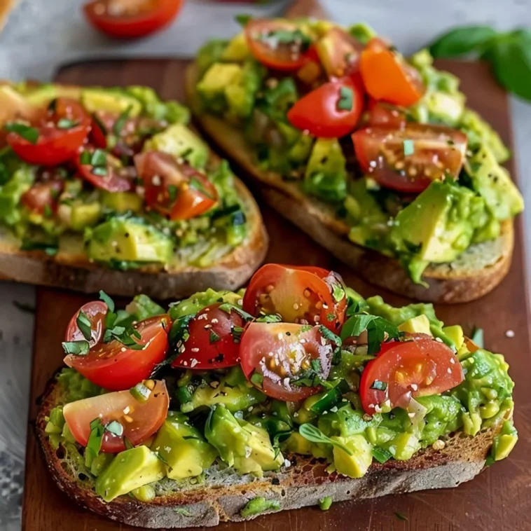 Avocadobrot mit Tomaten und Basilikum 2 Avocadobrot mit frischen Tomaten und Basilikum auf einem Holzbrett präsentiert.