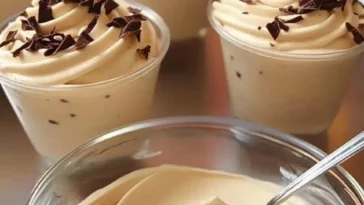 Becher mit schaumiger Cappuccino-Creme serviert