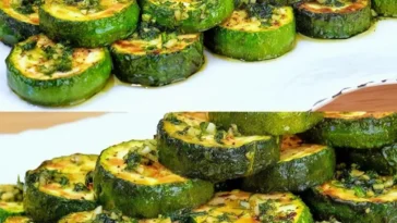 Gebratene Zucchini Ringe mit Kräutern und Knoblauchöl auf einem Teller