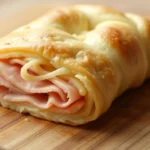 Gefüllter Blätterteigstrudel mit Schinken und Käse in nur 10 Minuten 4 Gefüllter Blätterteigstrudel mit Schinken und Käse auf einem Teller