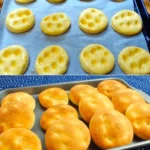Käse-Minibrötchen 3 Frisch gebackene Käse-Minibrötchen auf einem Holzbrett.