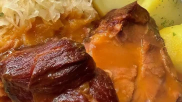 Kassler mit Sauerkraut und Kartoffeln auf einem Teller angerichtet