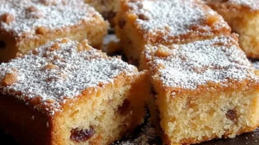 Marzipan Stollenkuchen mit Mandeln und Trockenfrüchten auf einem rustikalen Holzbrett