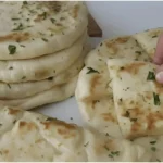 Räucherkäse gefüllte Knoblauchfladen 3 Räucherkäse gefüllte Knoblauchfladen auf einem Holzbrett
