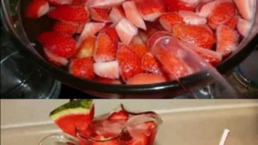 Sommerliche Erdbeer-Bowle mit frischen Erdbeeren und Melone serviert in einer Glaskaraffe