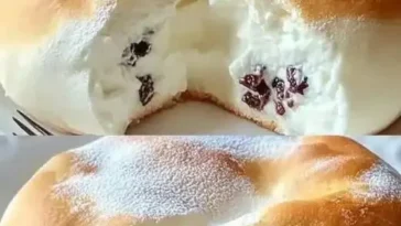Luftiger Wolkenkuchen auf einem Teller, verziert mit frischen Früchten und Sahne.