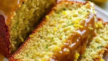 Zitronen-Zucchini-Brot frisch gebacken, mit Zitronenscheiben und Zucchini-Streifen.