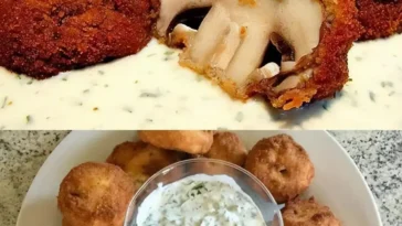 Panierte Champignons mit frischem Kräuterquark auf einem Teller serviert