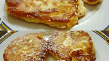 Quark Apfel Pfannkuchen auf einem Teller serviert, dekoriert mit Äpfeln und Puderzucker.