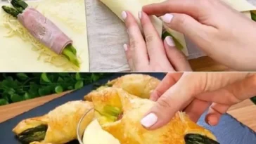 Rustikale Brötchen mit frischem Spargel auf einem Holzbrett