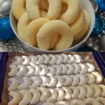 Sahnekipferl mit Kokos 4 Leckere Sahnekipferl mit Kokos, schön angerichtet auf einem Teller.