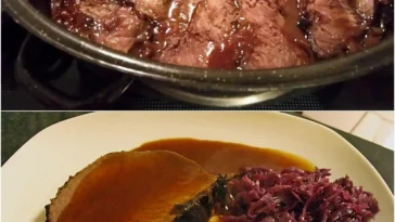 Sauerbraten mit Rotkohl und Kartoffelklößen auf einem Teller serviert.