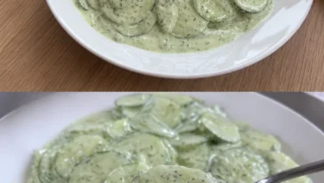 Frischer Gurkensalat in einer Schüssel mit Gewürzen und frischen Kräutern.